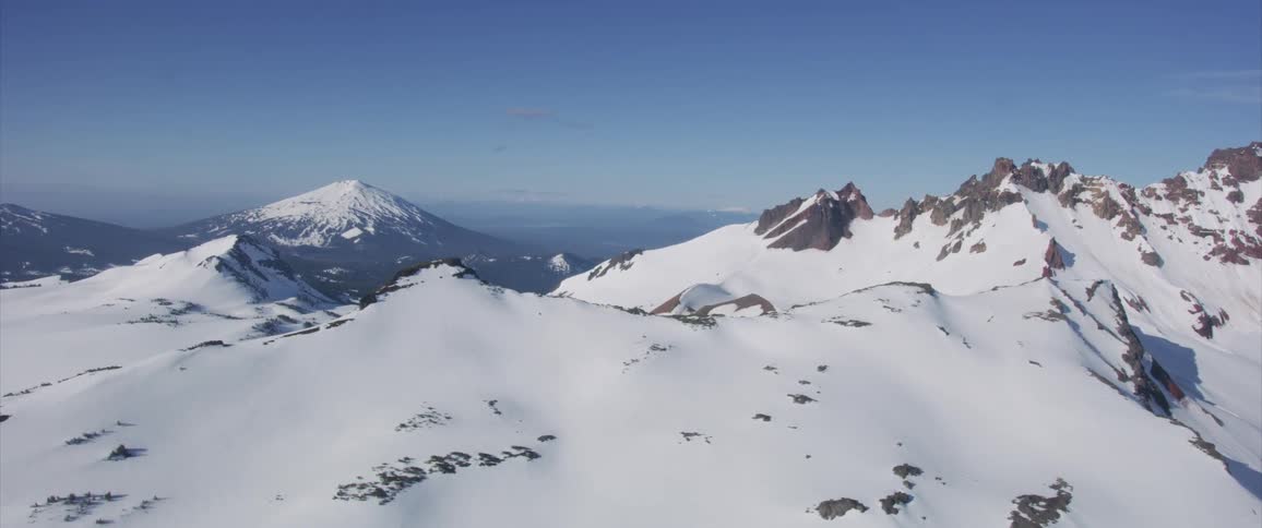 An aerial view of a snow covered mountain in the wilderness