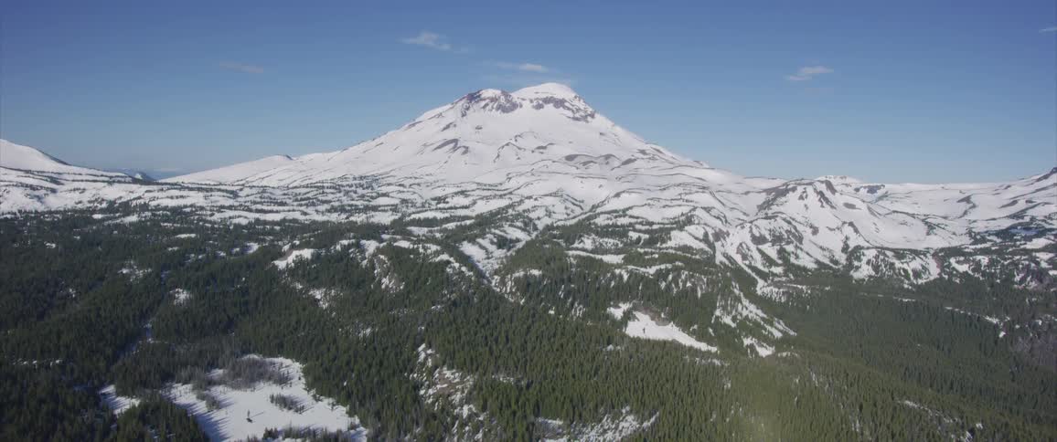 A mountain covered with snow with the sky in the background