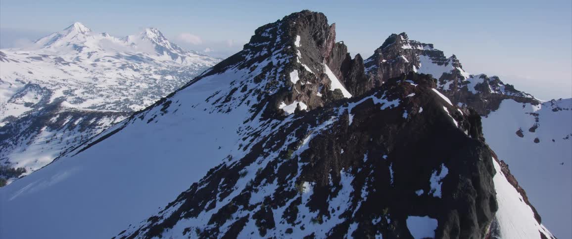 An aerial view of snow covered mountains in the wilderness