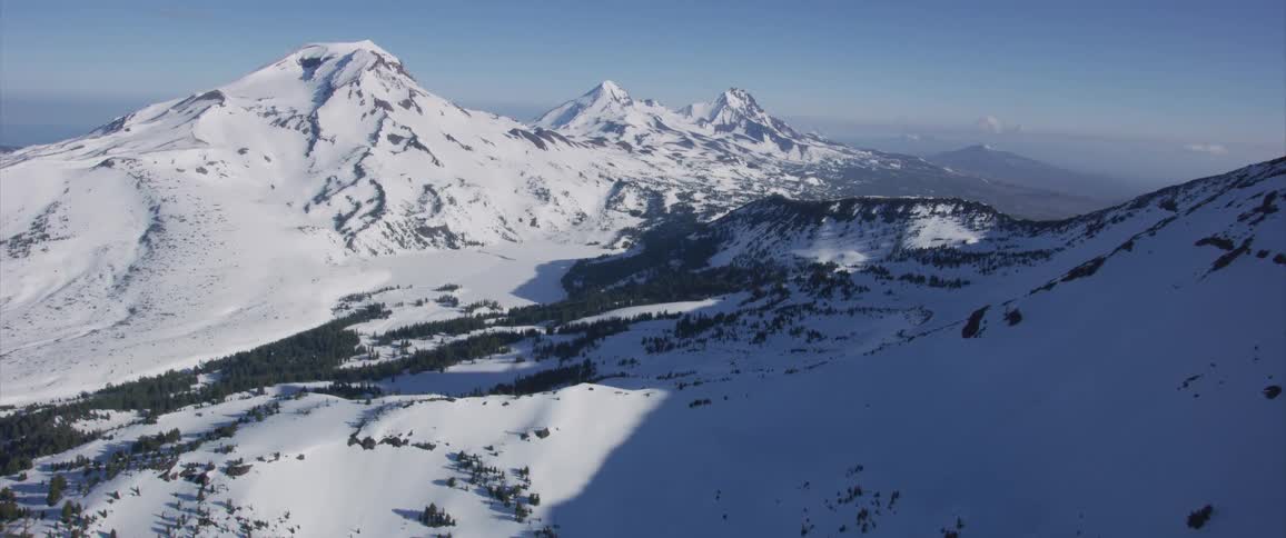 An aerial view of snowy mountains in the wilderness