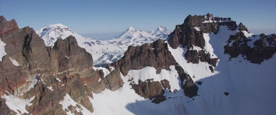 An aerial view of snowy mountains in the wilderness