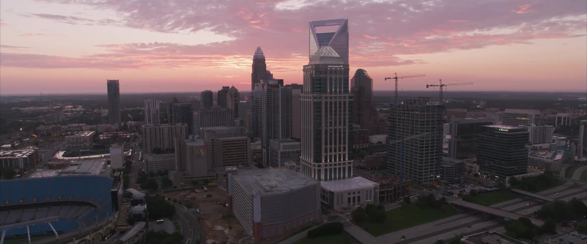 An aerial view of skyscrapers in a large city at sunset