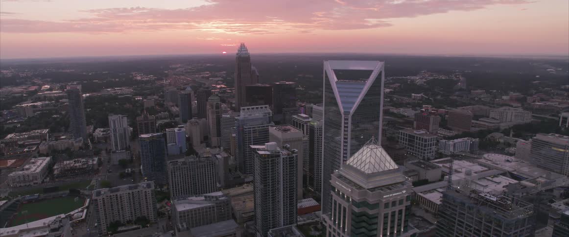An aerial view of skyscrapers in a large city at sunset