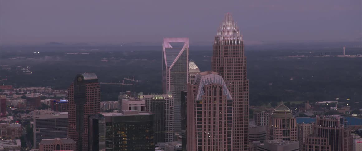 An aerial of skyscrapers in a large city at sunset