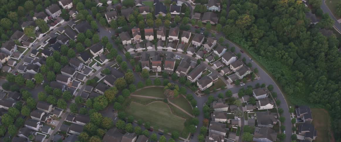 A suburban neighborhood is surrounded by trees