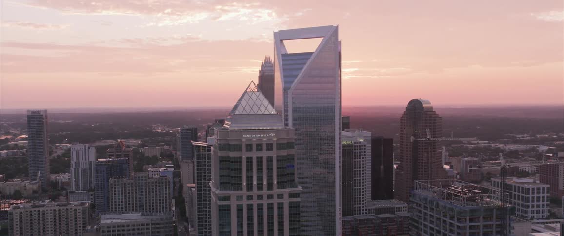 The sun sets over skyscrapers in a large city