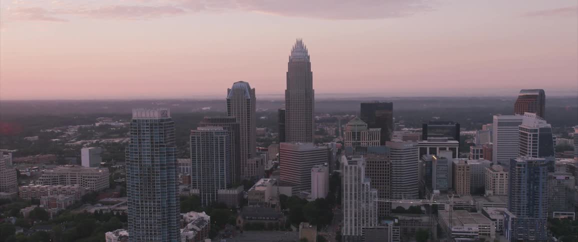 An aerial view of skyscrapers in a large city at sunset