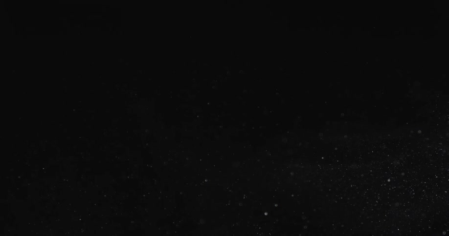 White particles floating against a dark background