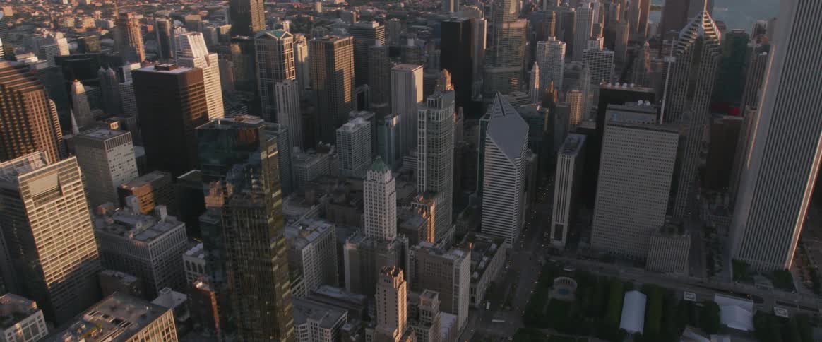 Flying over a large city with a park in the center of it
