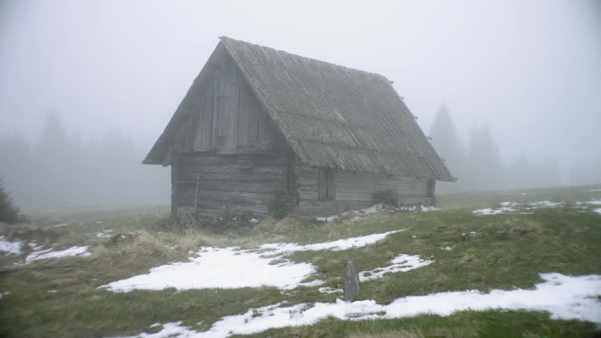 An old wooden building in a snowy field