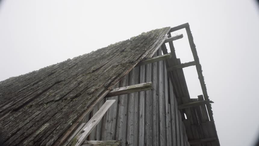 A person knocking on a old wooden house