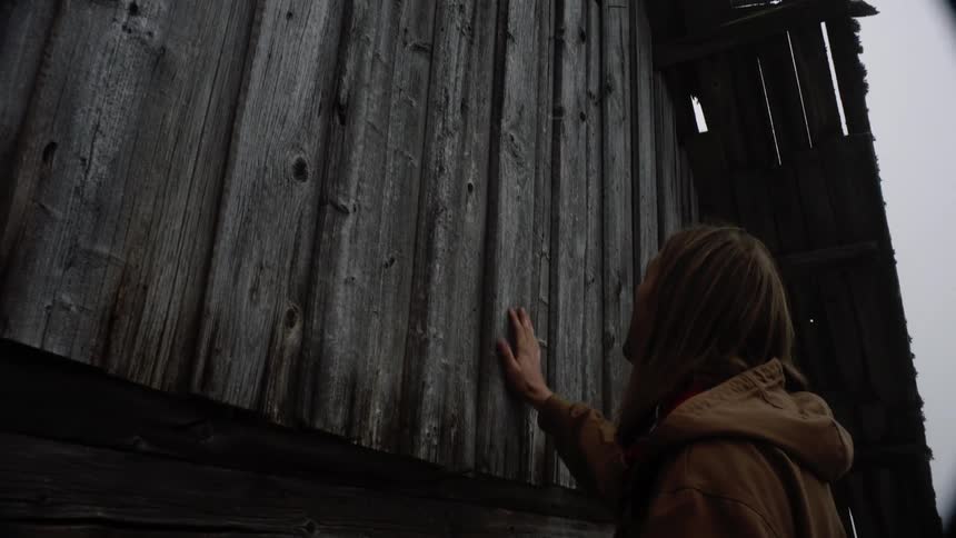 A woman is standing outside of a house