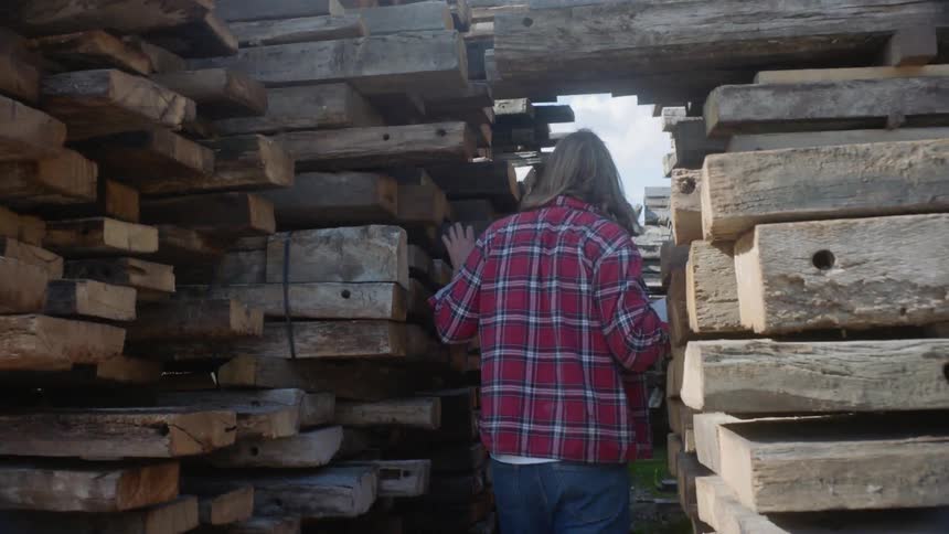 A man walks through a tight wooden pathway