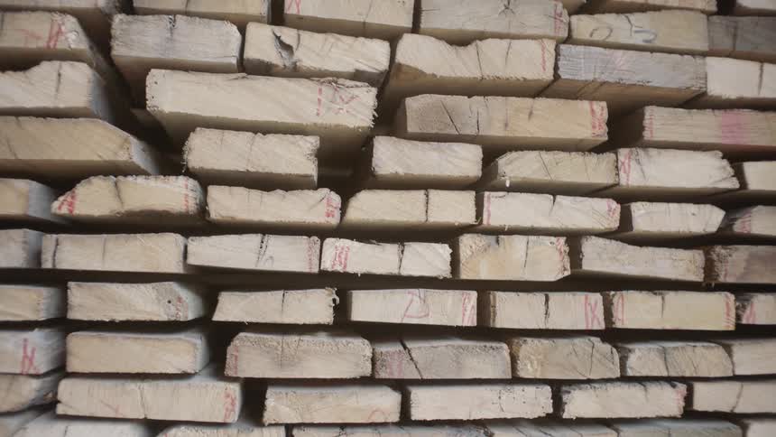 Wooden boards are stacked neatly in a pile