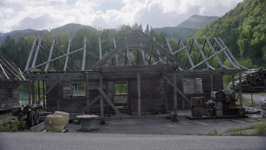 An unfinished wooden structure by the side of a road