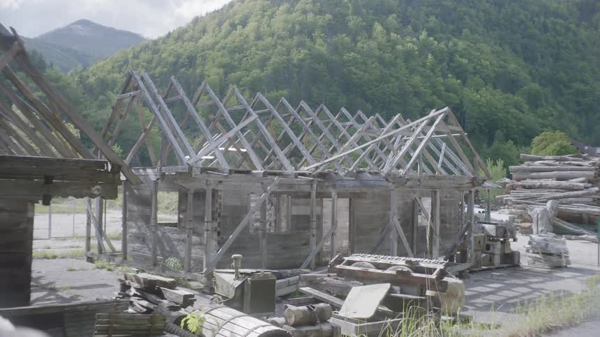 Weathered homes in midst of construction near forest and mountains