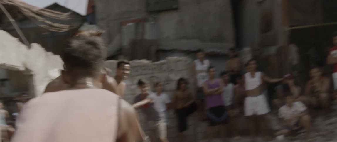 A boy dribbles a basketball while being guarded during a game of two on two at an outdoor hoop
