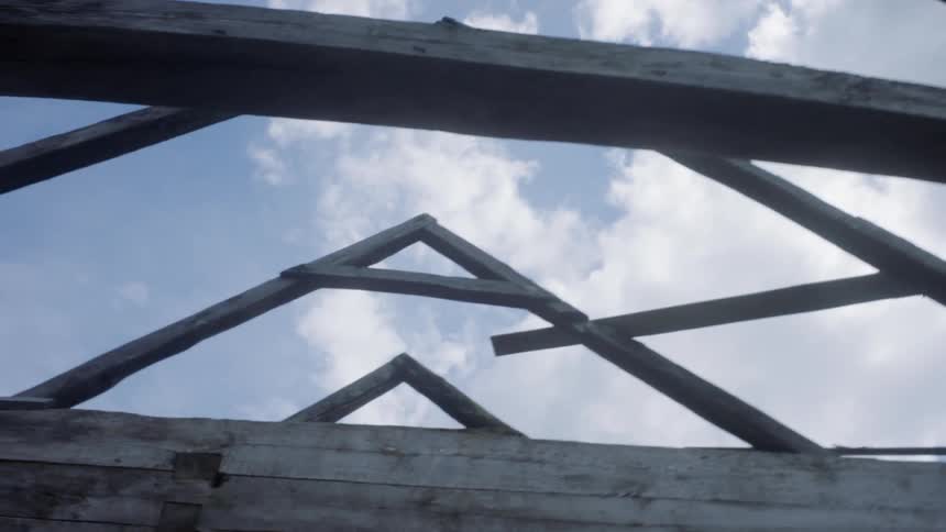 The wooden frame of a cabin roof during the day