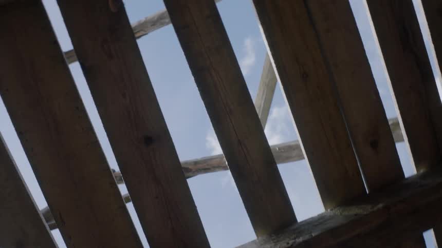 The camera spins around under a wooden framework