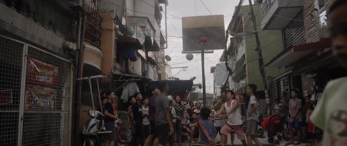 Children and teenagers play street ball in the suburban area in the daytime