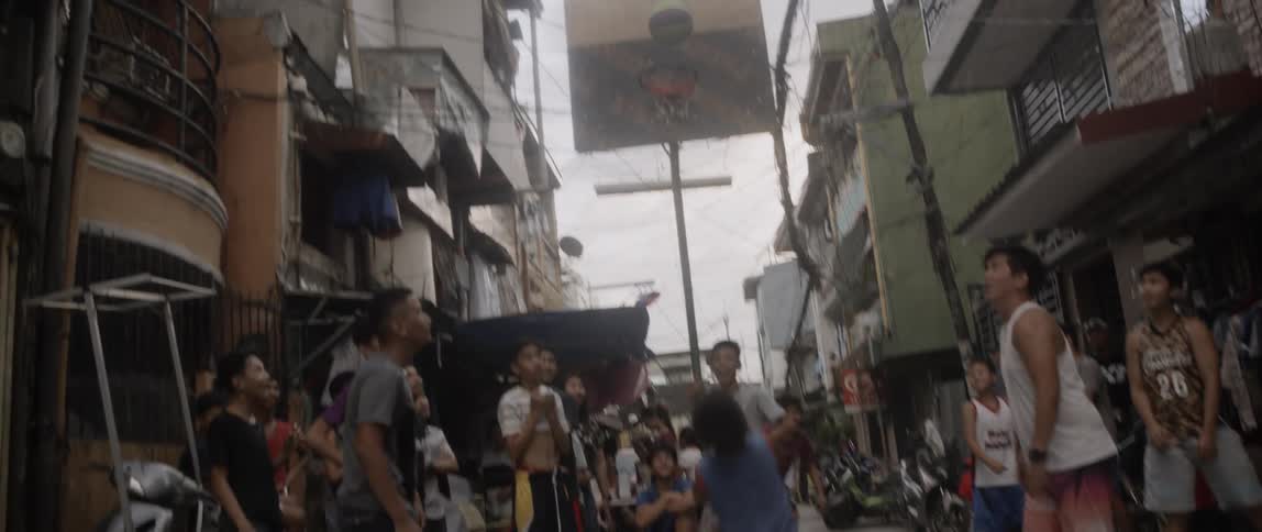 A group of people playing basketball in the streets
