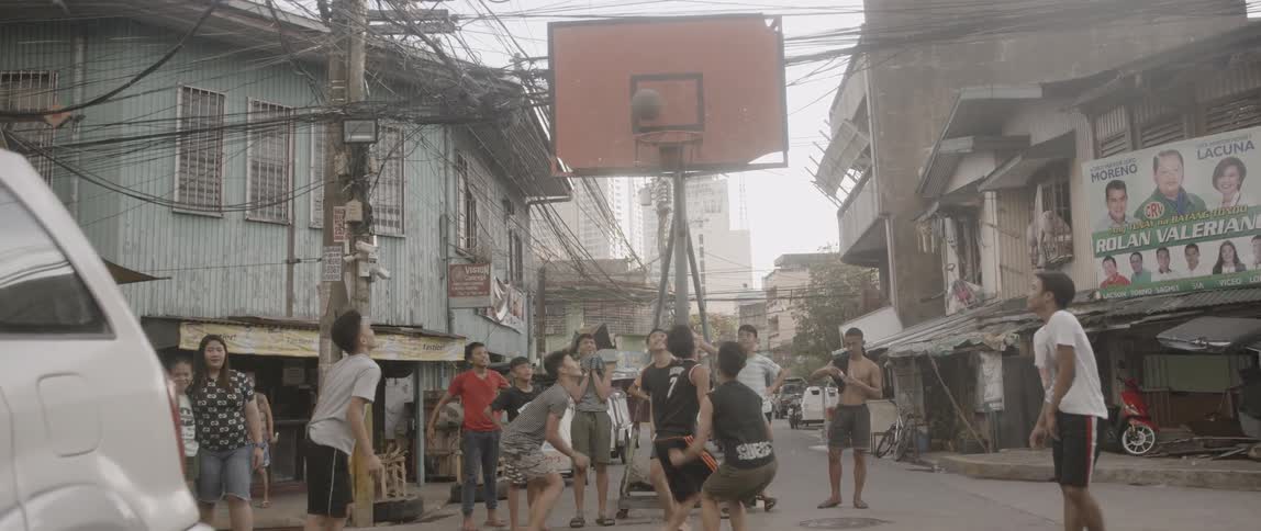 A group of kids playing basketball in the street