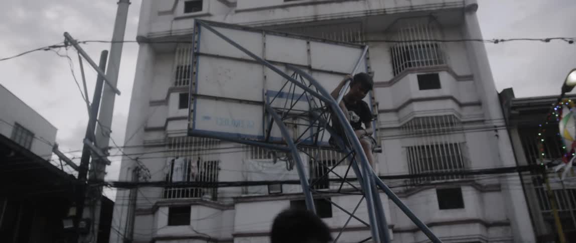 A group of men pushing around a basketball hoop