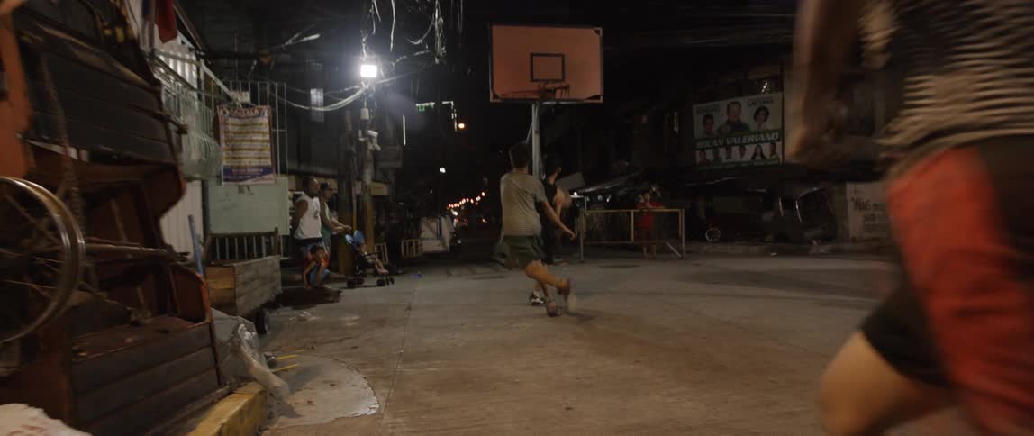 Kids playing basketball in a crowded urban street