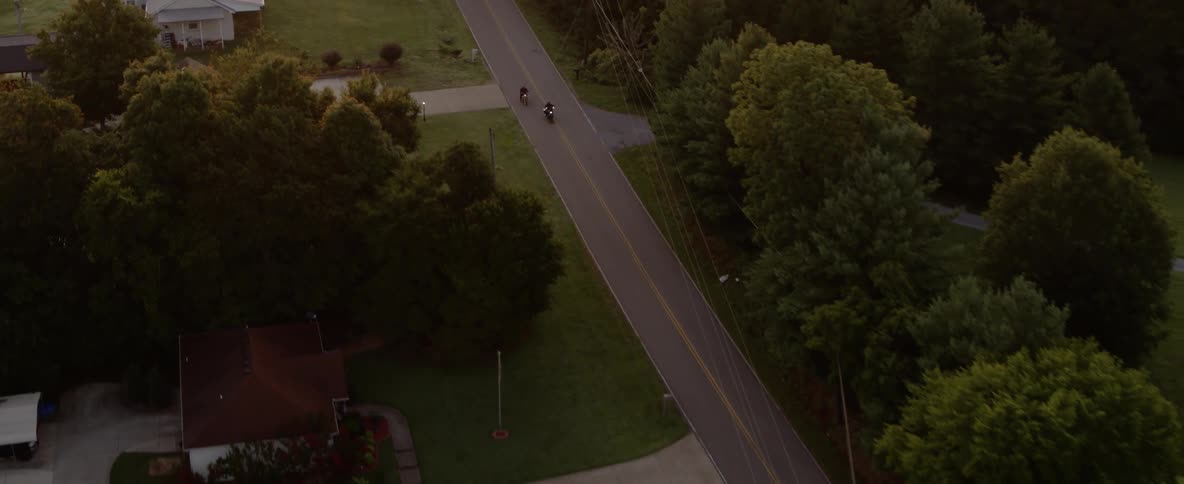 Aerial shot of motorcycles traveling down rural highway