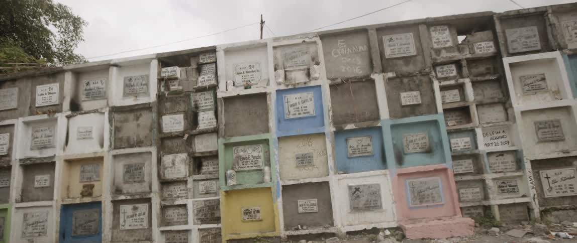 Children play basketball by the graveyard