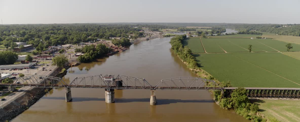 An aerial view of a river next to a city and farmland
