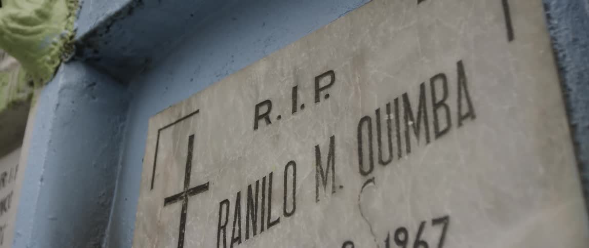The side of the building has a carving with a name in the graveyard