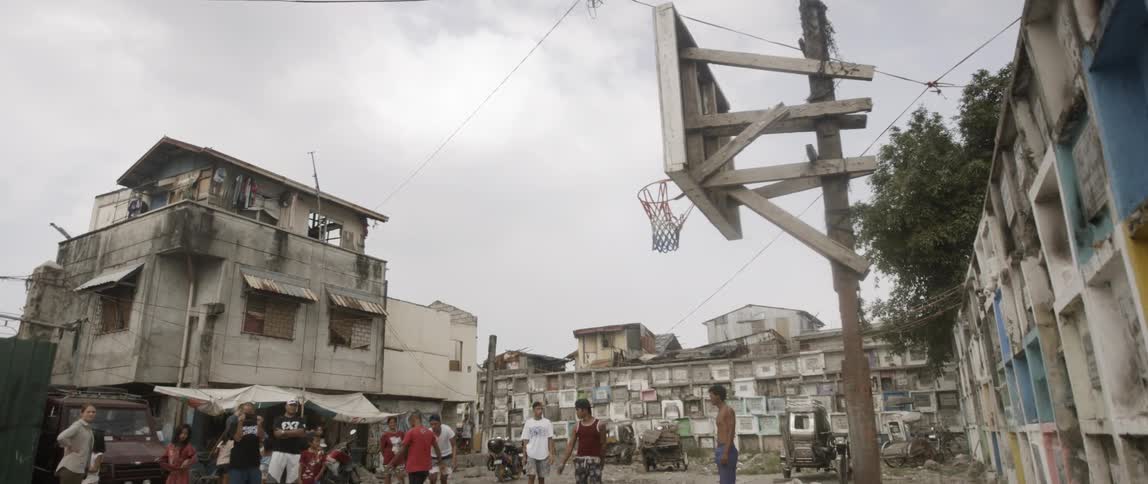 Boys playing basketball in a run down area