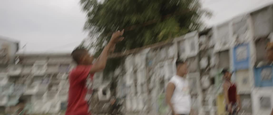 Kids and teens playing basketball on a public court in a poor area