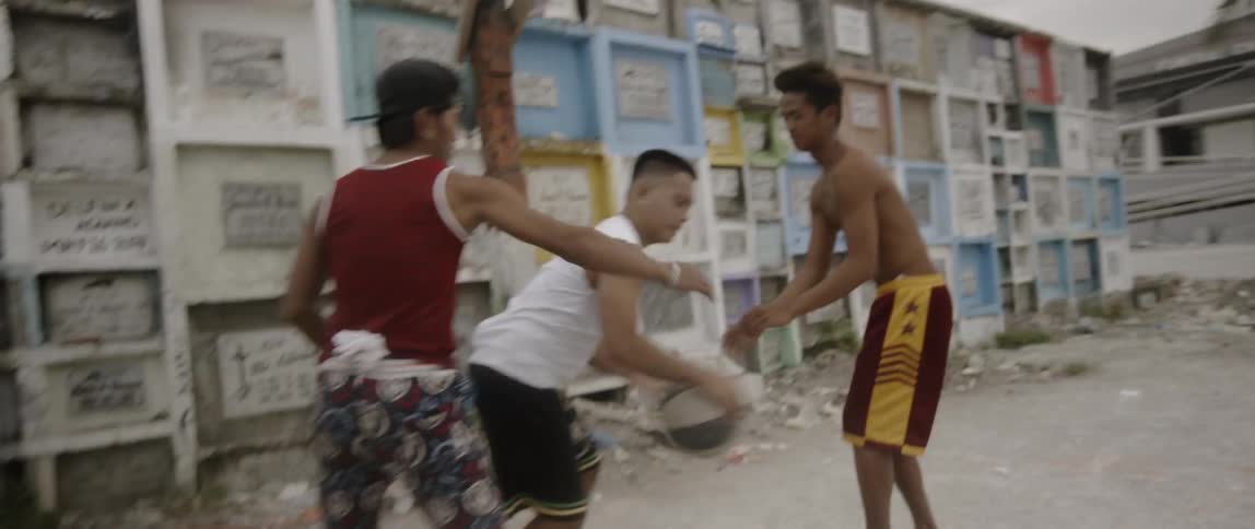Teenagers play street ball in the suburban area on a cloudy day
