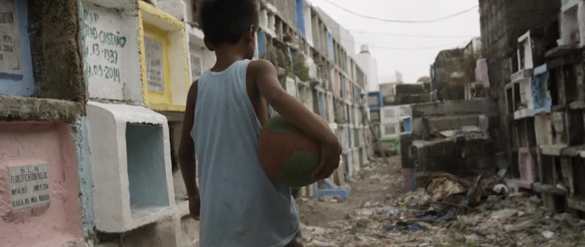 Boy carriers basketball through debris strewn alley