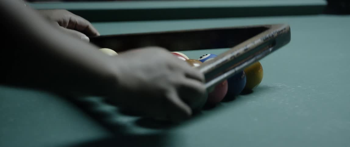 A man racks up pool balls on a table