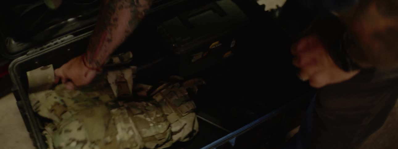 A man placing a hunting vest in a container