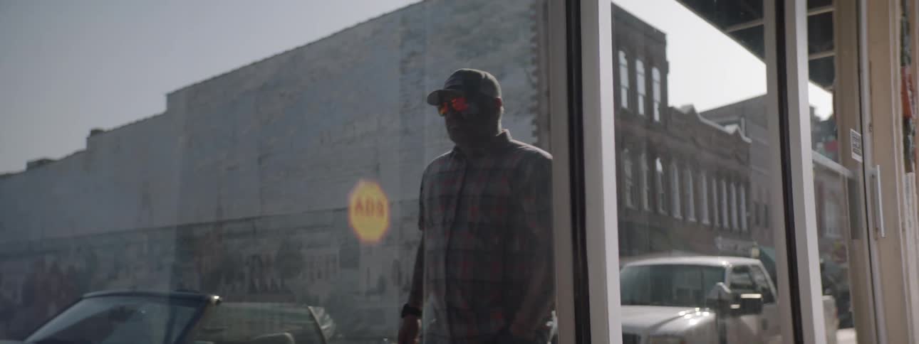 A store window with the reflection of a man walking his dog