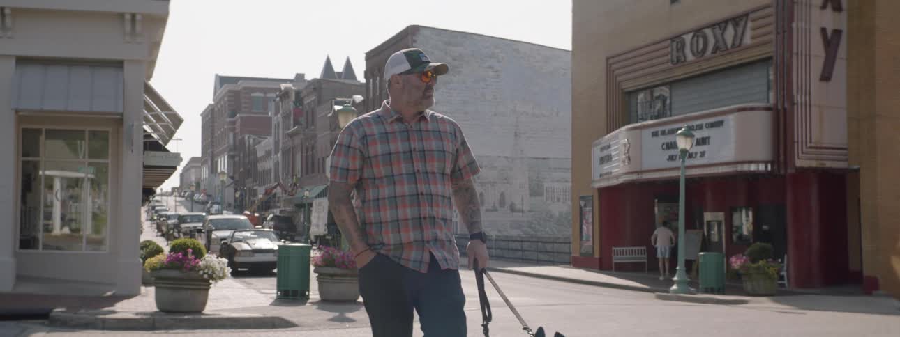 A man crosses the street with his dog in town
