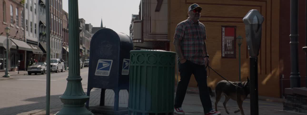 Man and his dog walking through town in a small old town