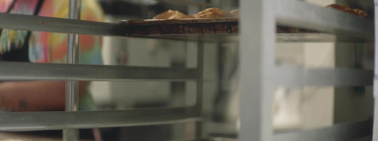 Trays of baked goods rest on a food serving cart