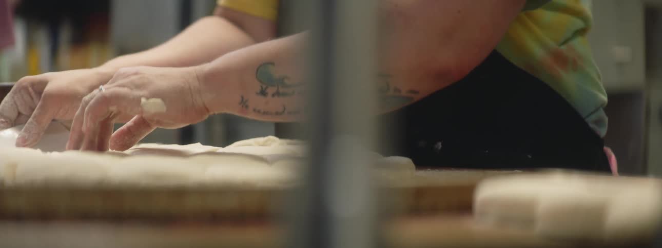 Tattooed man making bread