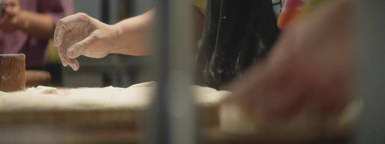 A person is working with dough in a restaurant