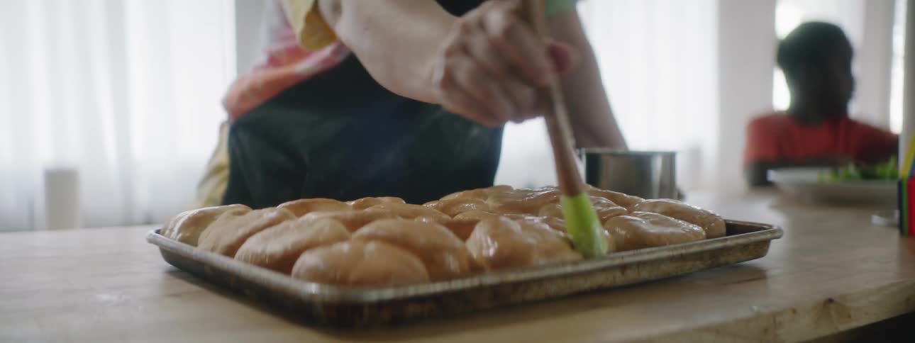 Woman glazes rolls