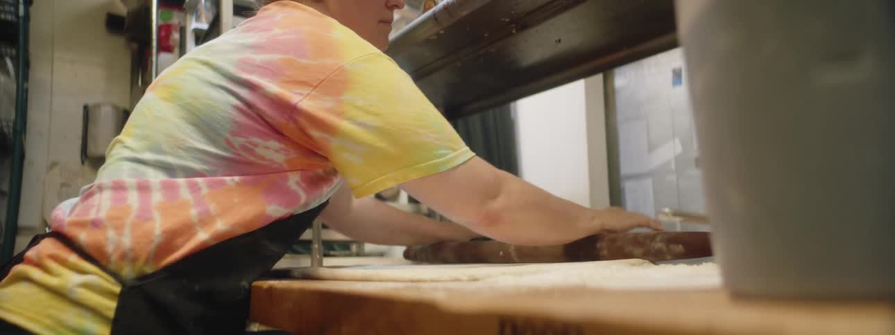A woman rolls out dough