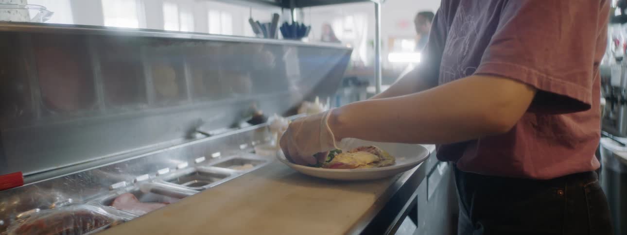 A chef preparing a salad on a plate in a restaurant