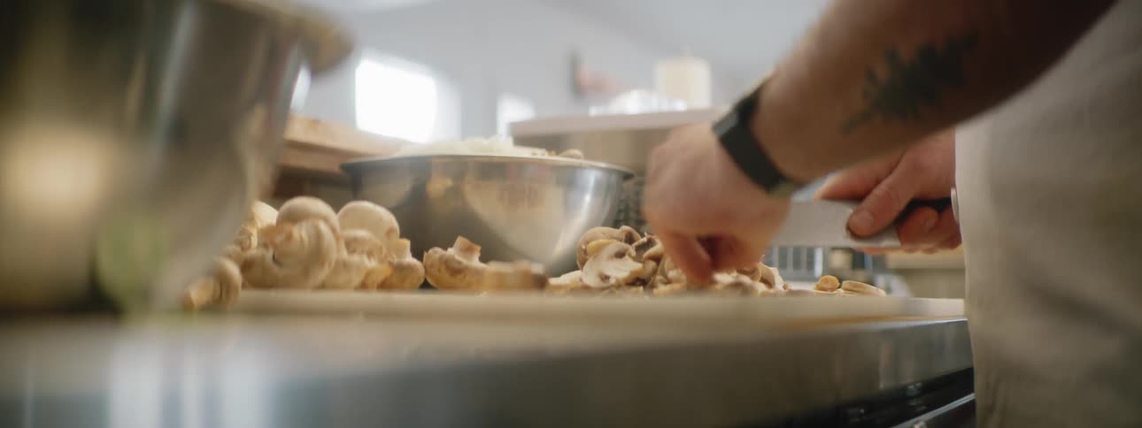 A chef chops mushrooms on a cutting board