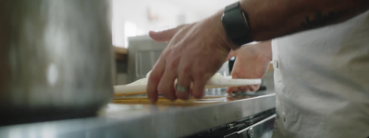 Man cuts onion on cutting board and puts slices into pot