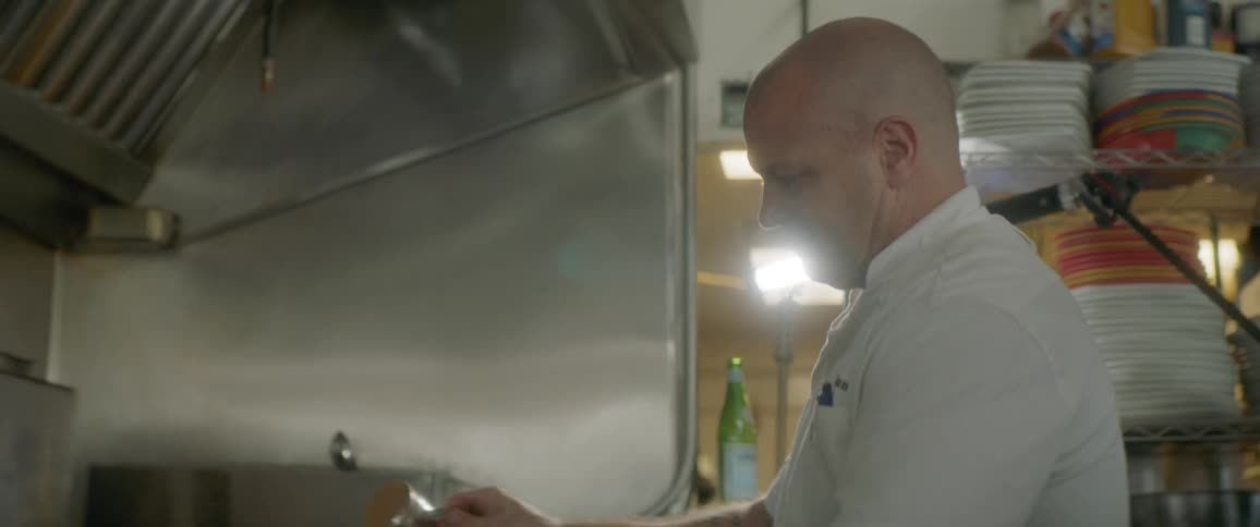 A chef adds some spice to a flaming skillet